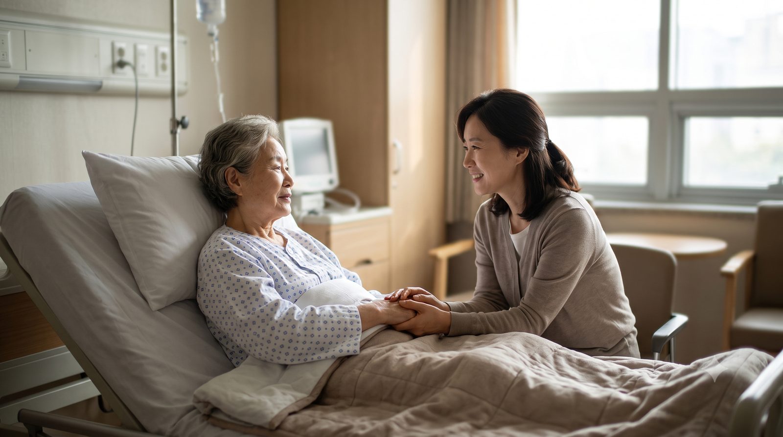 환자의 손을 다정하게 잡아주는 보호자